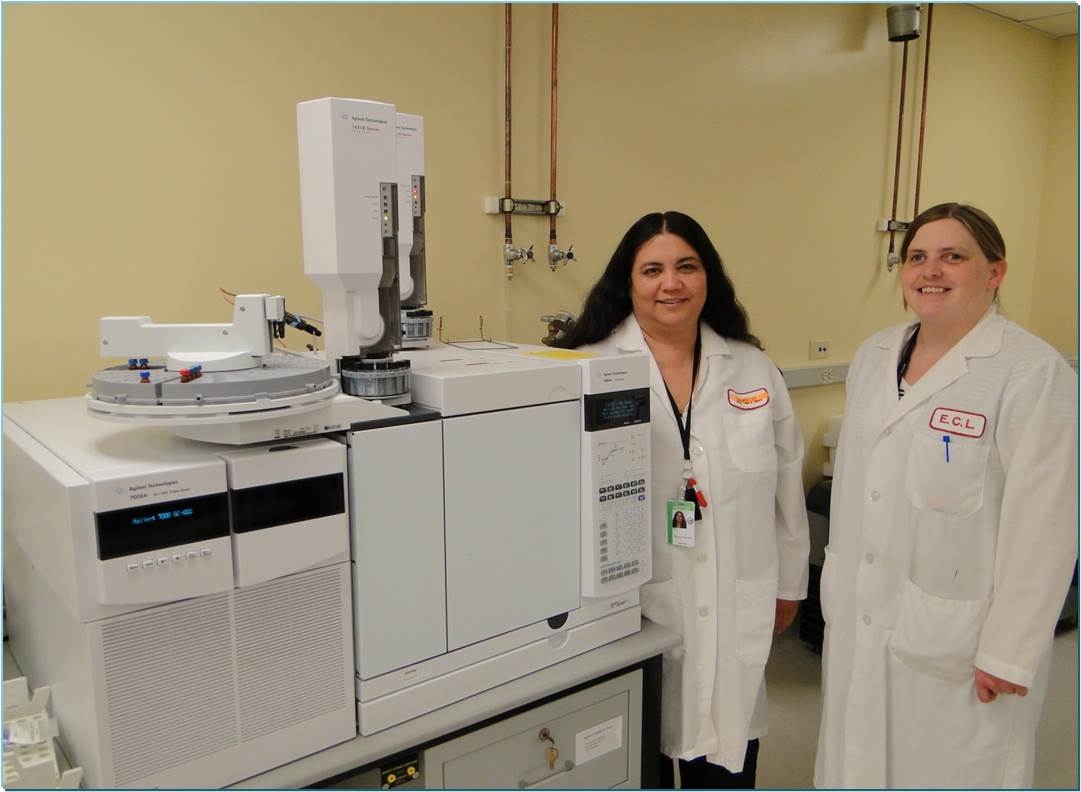 Two women standing near large lab equipment