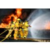 Firefighters fighting flames, wearing full protective suits and holding large hoses spraying water