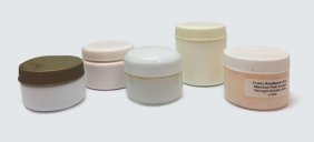 Several different sizes and colors of unlabeled skin cream containers